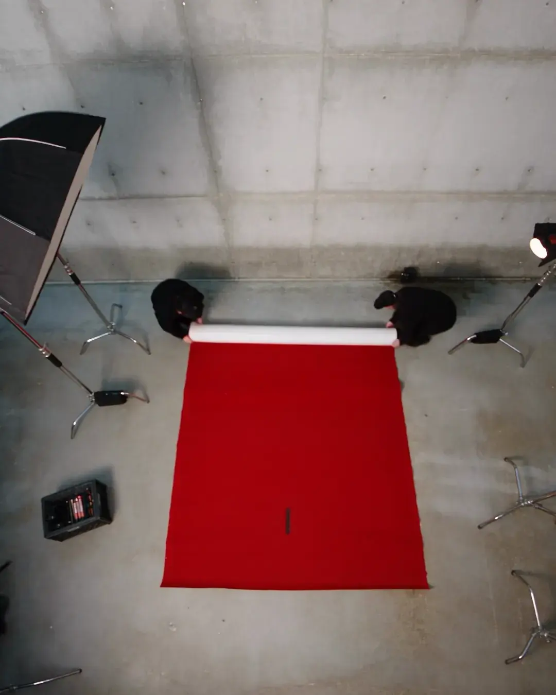 The set seen from above before anyone is on it: a red sweep laid on the floor, two lights placed, a mark on the concrete