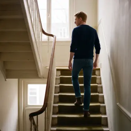 A guest walking up the old staircase