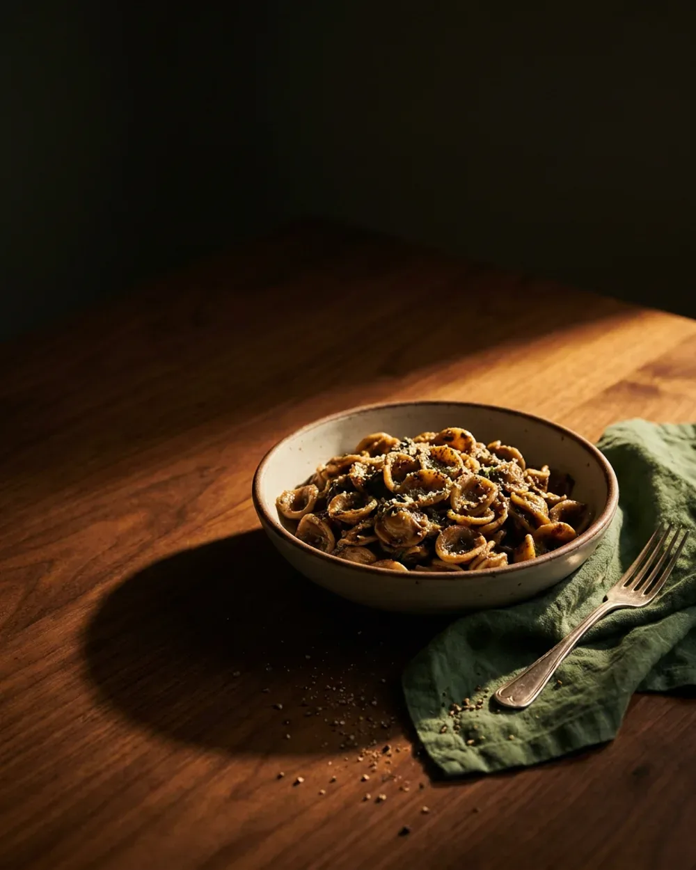 The same bowl of pasta art-directed with raking light and a considered palette